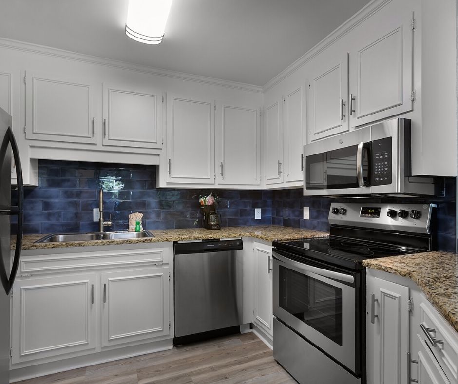 Renovated kitchen with stainless steel appliances and white cabinets