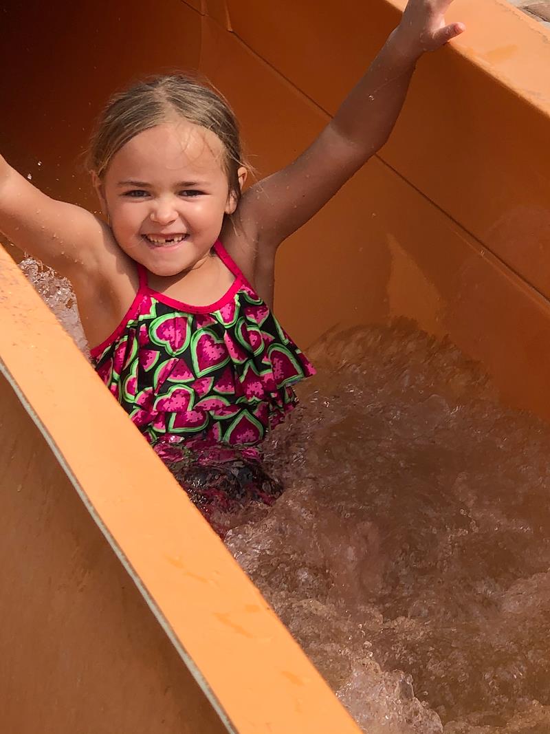 little girl riding down slide