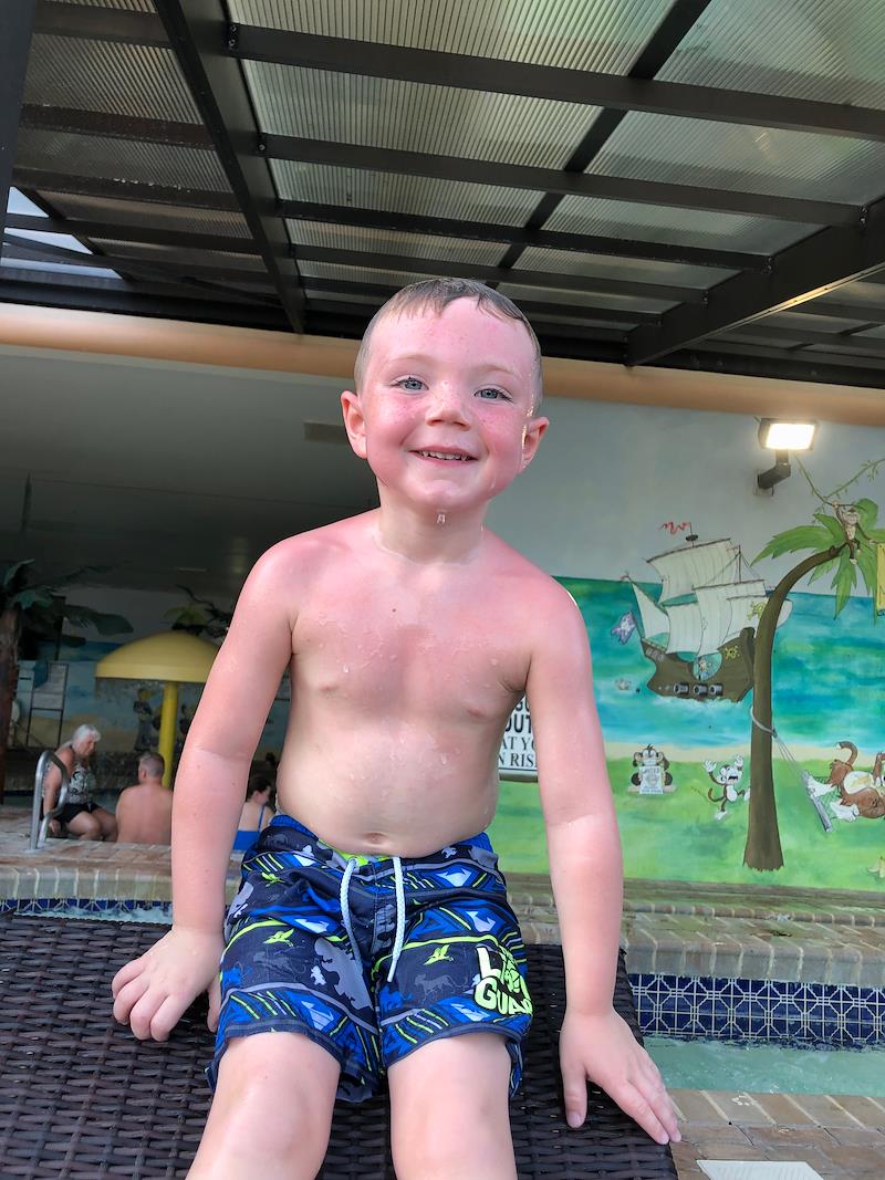 little boy smiling in pool