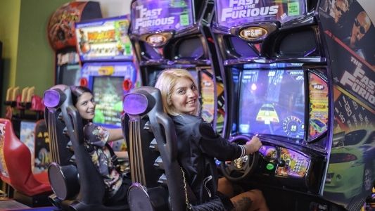 Girls playing a car racing arcade game