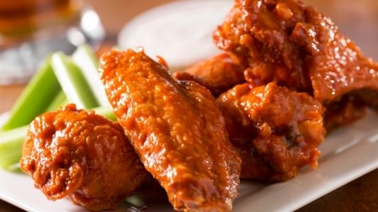 Buffalo chicken wings sitting on a plate with celery