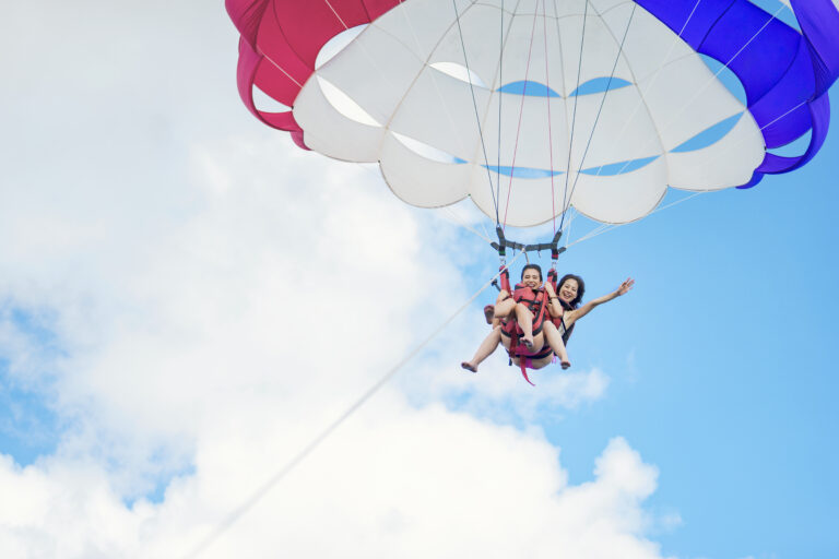 Two women parasailing on a sunny day