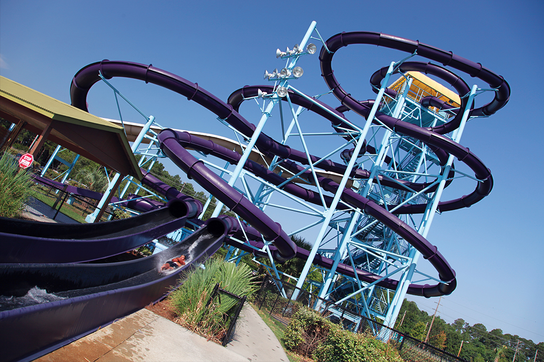 A large purple water slide with a metal structure and blue supports