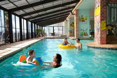 Caribbean Family Swimming in Indoor Pool