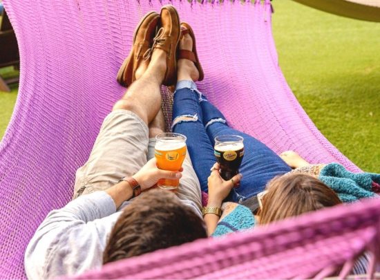 Couple Laying on Hammock with Beers