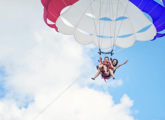 Two women parasailing on a sunny day